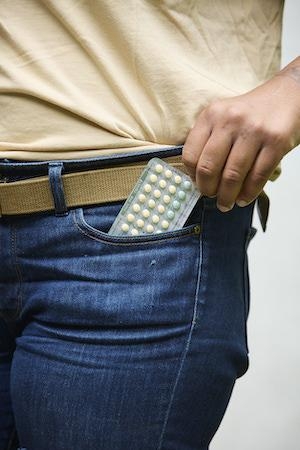 Person with birth control pack in their front pocket